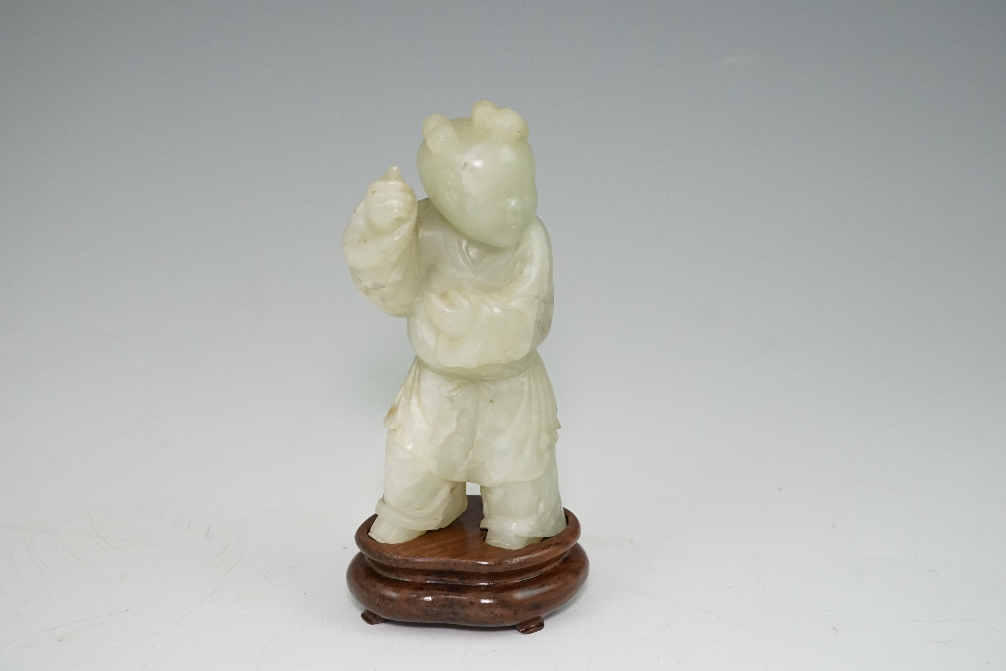 A Chinese pale celadon jade figure of a boy, 18th century